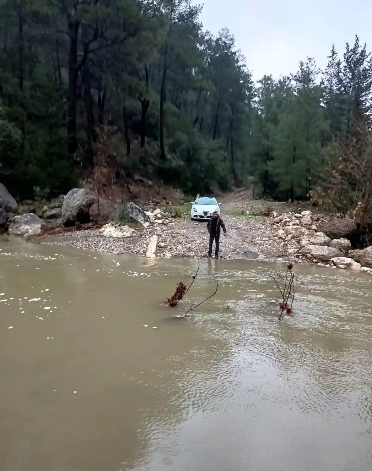 Derenin debisi yükselince aracıyla mahsur kaldı