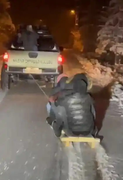 Cipin arkasına bağladıkları kızakla kayak keyfi yaptılar