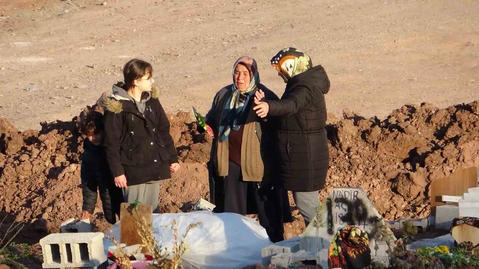 Depremde yakınlarını kaybeden aileler mezarlıklardan ayrılmıyor